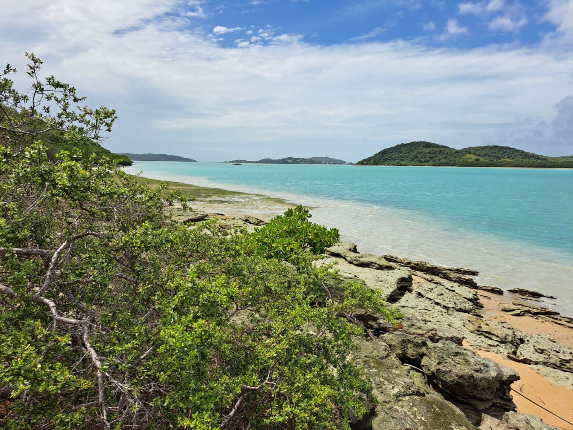 Far North Queensland landscape featuring rocks, sand and water in the foreground and islands in the distance